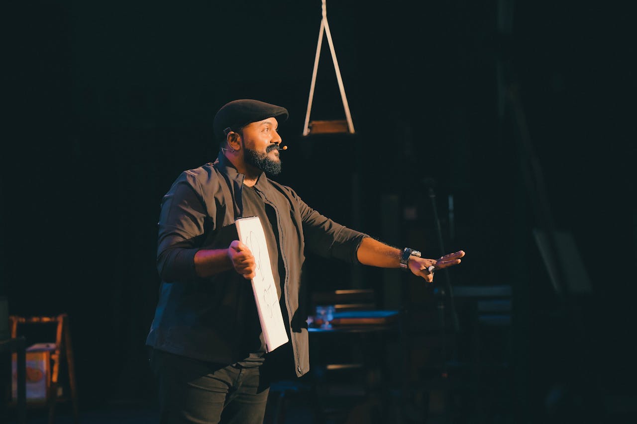 Male speaker passionately presenting on stage with a microphone, engaging the audience.